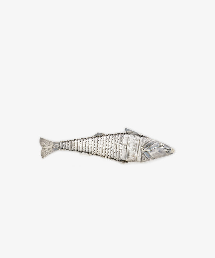 The Vintage Silver Articulating Fish charm features detailed scales and movable segments, resembling a lucky talisman, beautifully displayed on a plain white background.