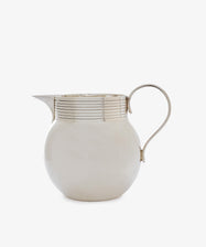 The Vintage Modern English Silver Jug from the 1950s features a sculptural form with a rounded body, curved handle, spout, and decorative horizontal lines near the top.