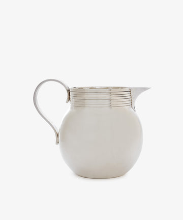 The Vintage Silver Jug is a round, English-style piece with a curved handle and spout, decorated with horizontal grooves near the rim, shown on a plain white background.