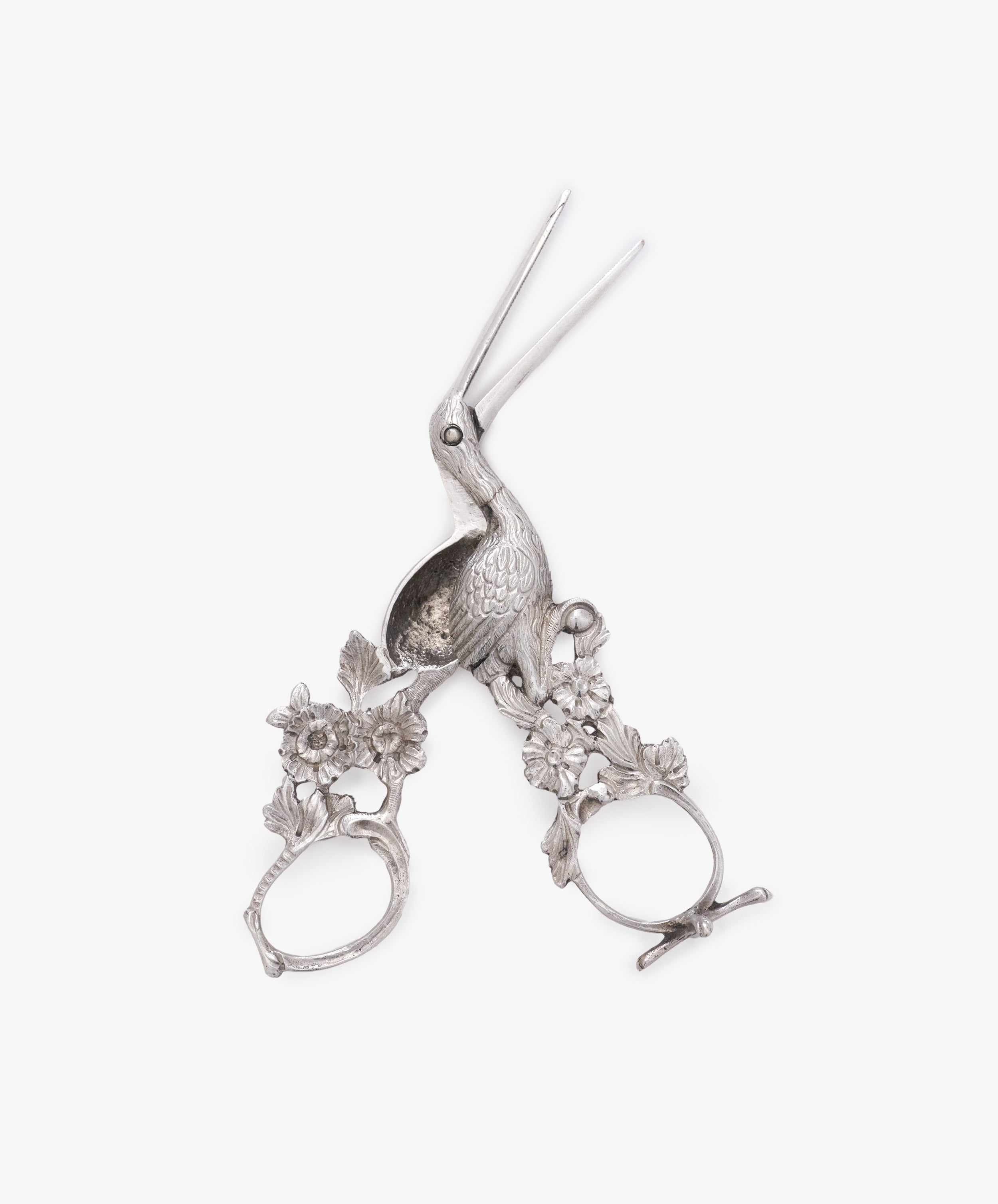Vintage Dutch Silver Ribbon Nips with a bird motif and floral handle detailing, reminiscent of stork scissors, are displayed on a white background.