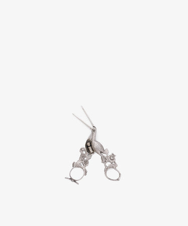 The Vintage Dutch Silver Ribbon Nips are ornate, silver-colored scissors inspired by vintage sewing tools, with intricate handle details, displayed on a white background.
