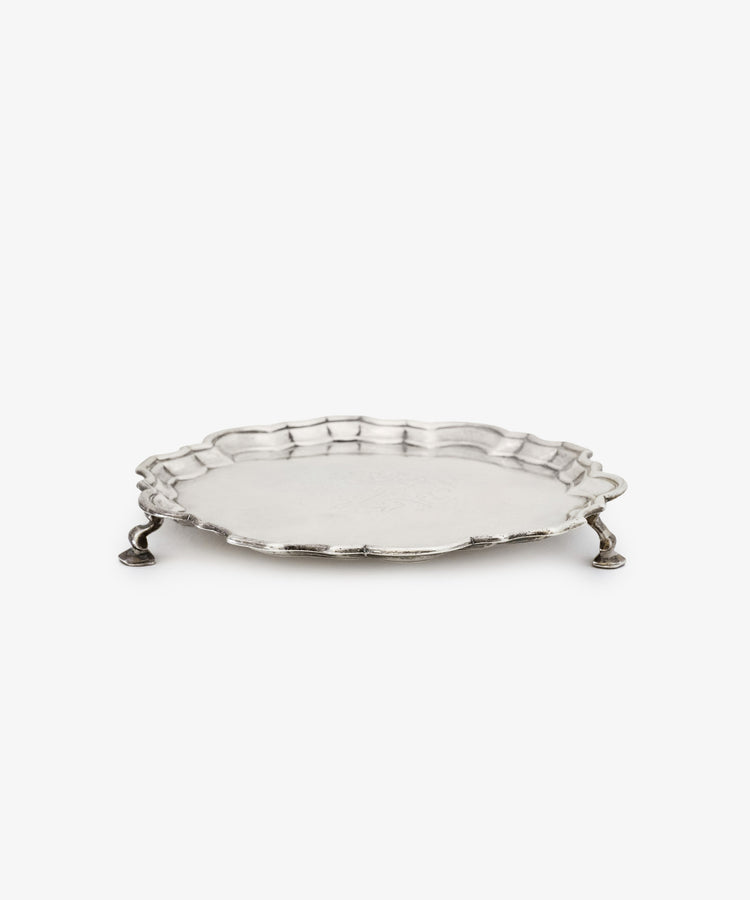 A Vintage English Salver with a round scalloped edge and three ornate legs, crafted in silver by Thomas Farren in the 18th century, displayed on a plain white background.