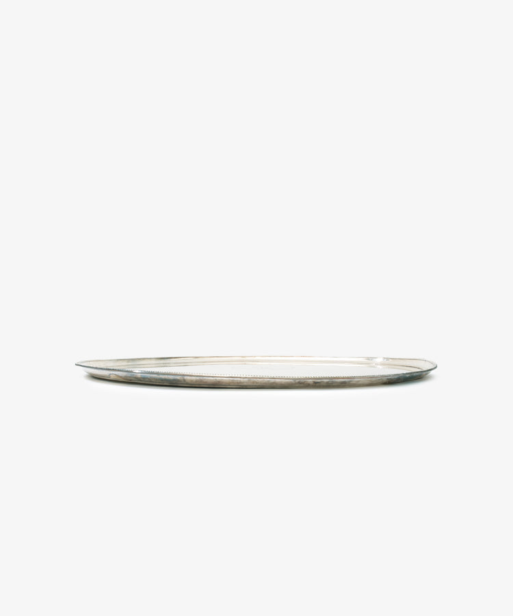 A vintage large silver tray with crest and motto Fidele is displayed against a plain white background, highlighting its elegant craftsmanship and flat, oval shape.