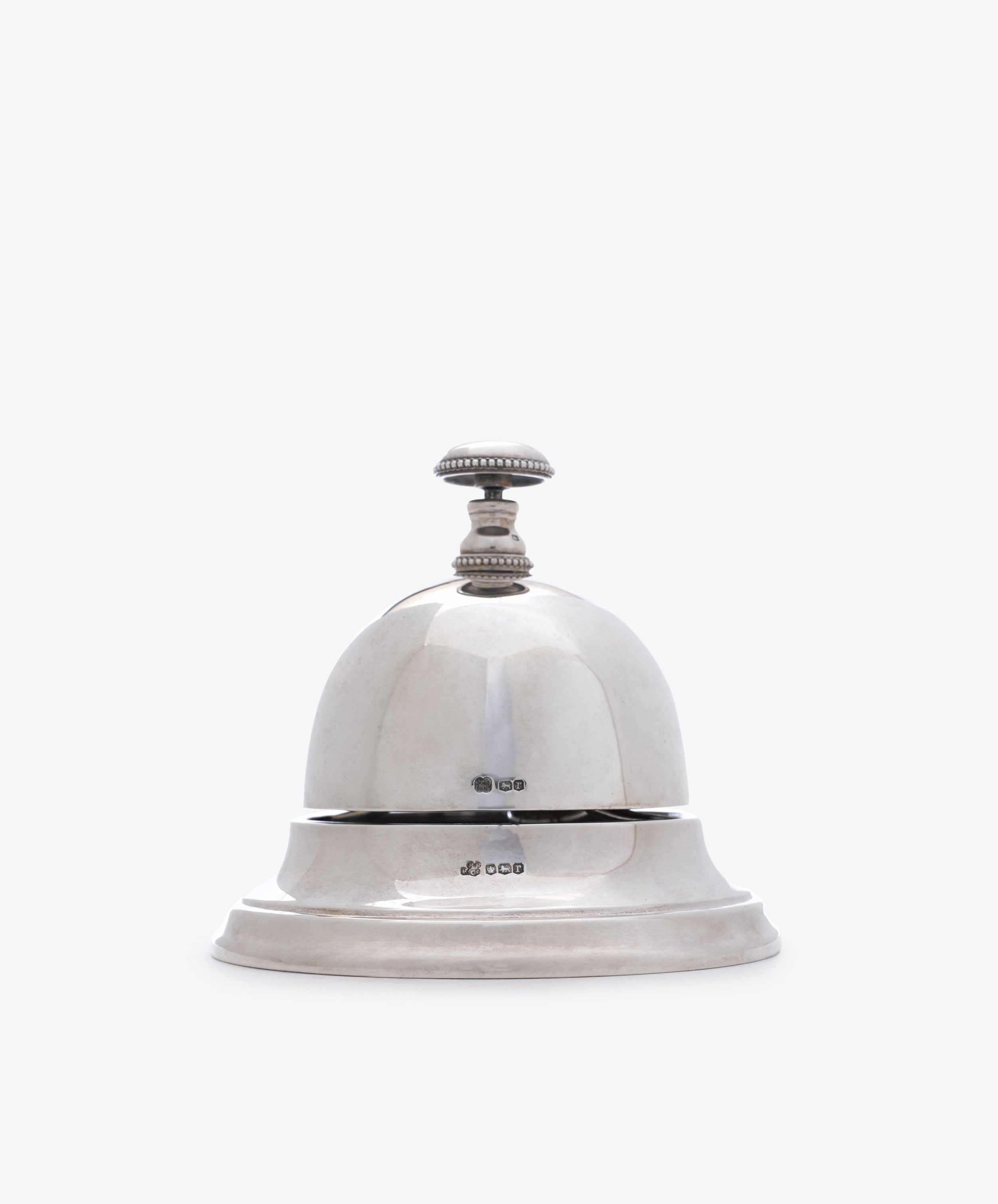 The Vintage English Silver Table Bell features a round dome and a knob on top, set on a flat base, ideal as a dinner bell or elegant household accessory. Presented against a plain white background.