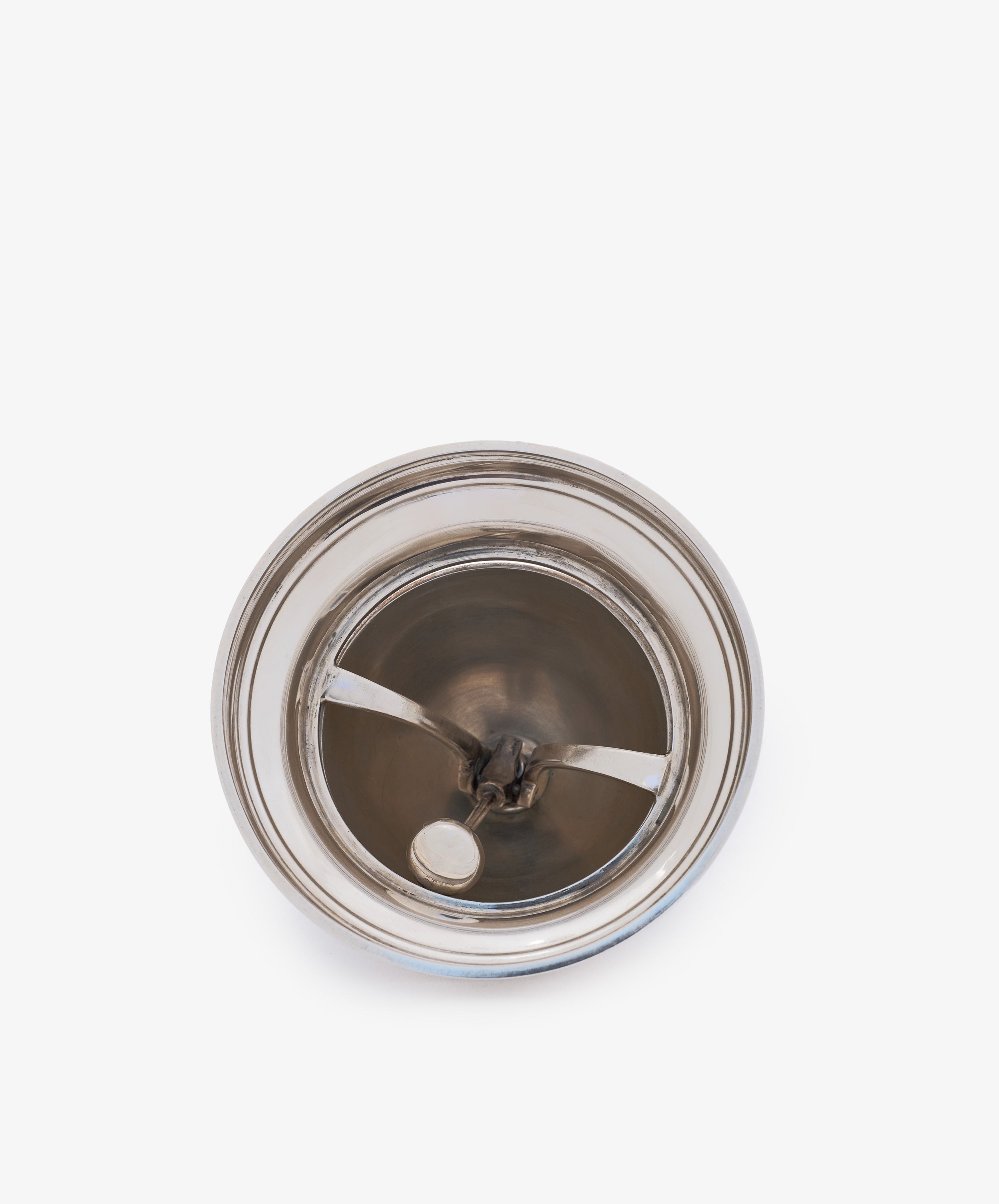 Top view of a Vintage English Silver Table Bell, this sleek household accessory gleams like silver against a plain white background.