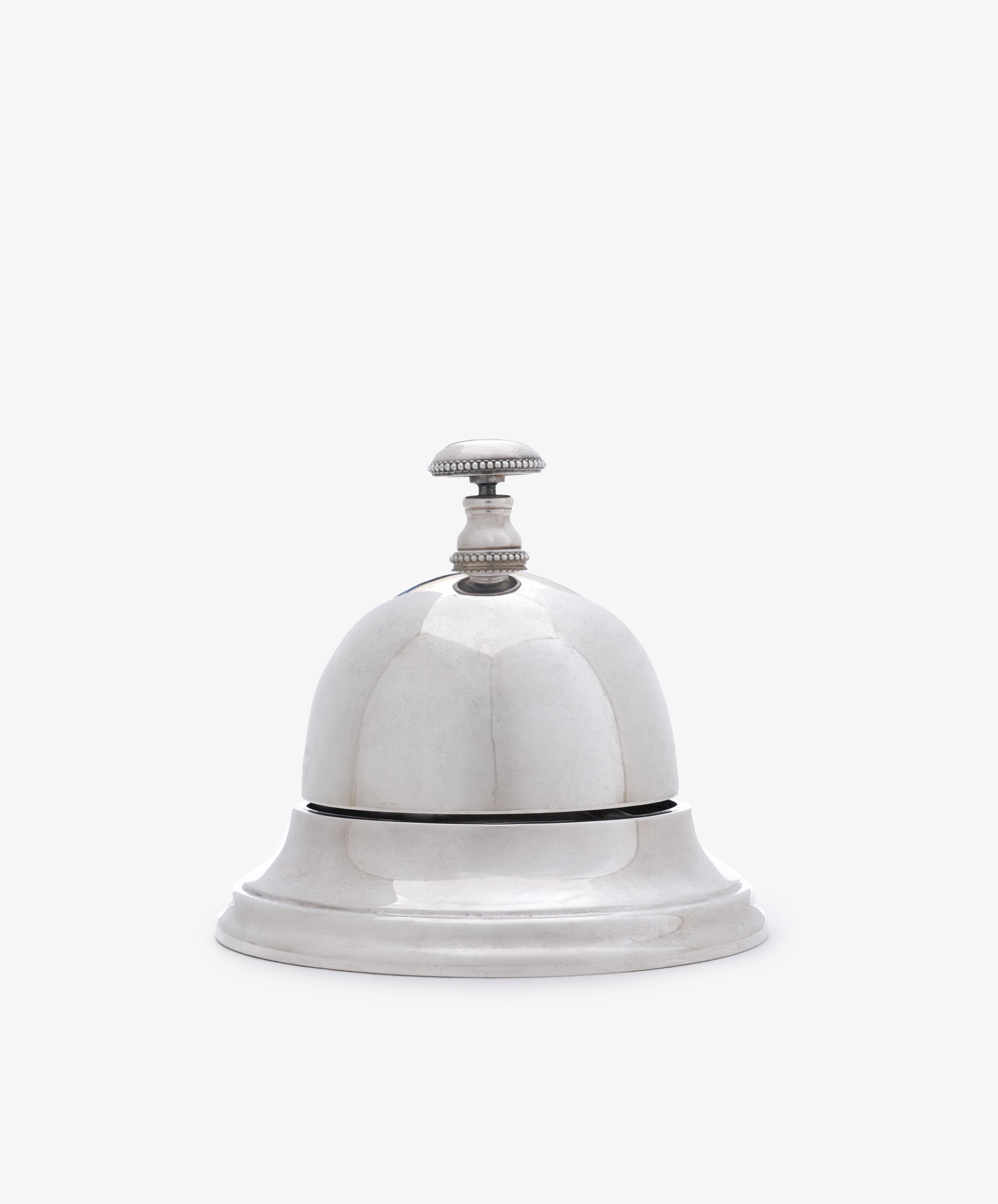 The Vintage English Silver Table Bell features a classic design with a handle, making it a charming addition to any home—perfect as a dinner bell or stylish décor accent.
