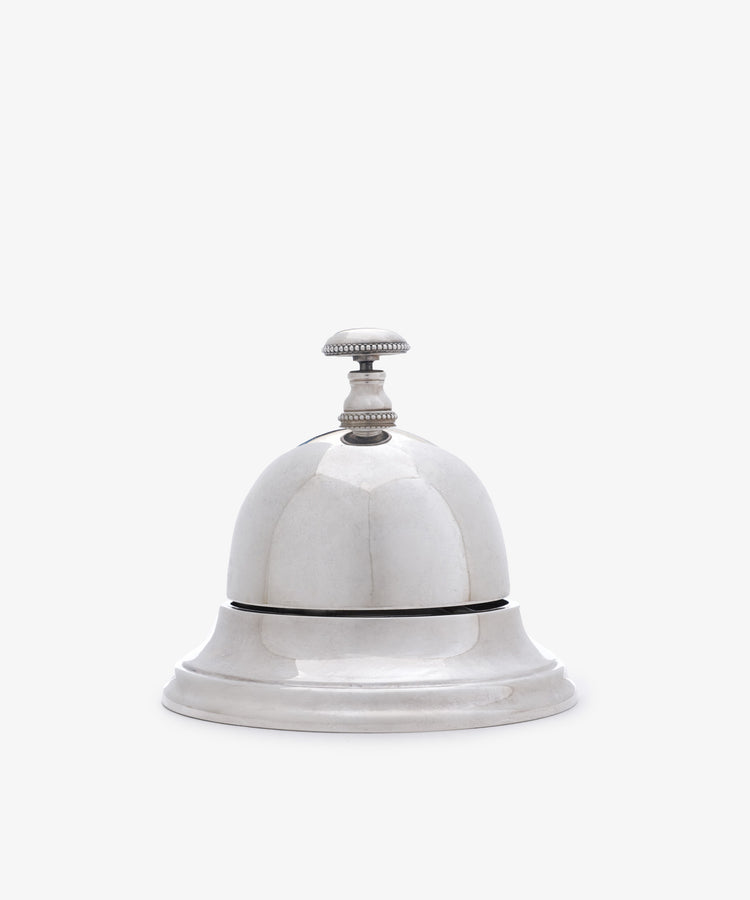 The Vintage English Silver Table Bell features a classic design with a handle, making it a charming addition to any home—perfect as a dinner bell or stylish décor accent.