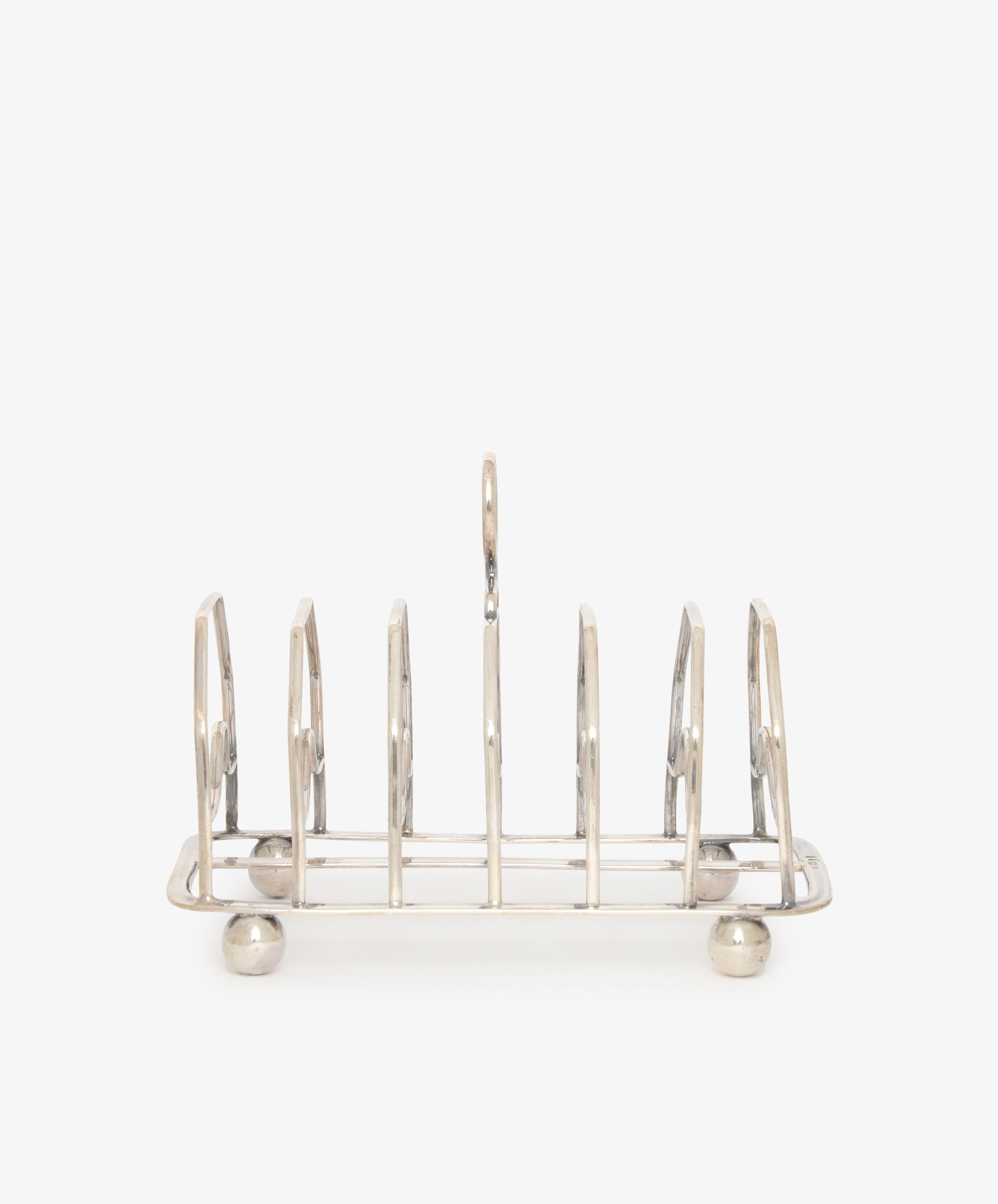 The Vintage George III Toast Rack is beautifully crafted in English silver, featuring six slots and four round feet, displayed on a plain white background.