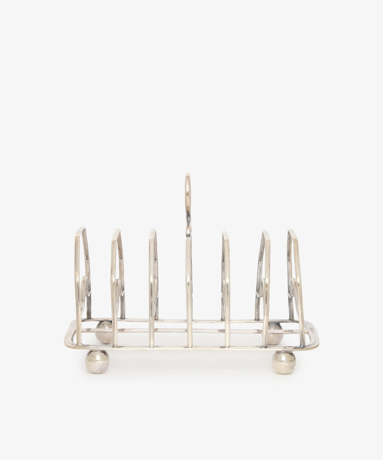 The Vintage George III Toast Rack is beautifully crafted in English silver, featuring six slots and four round feet, displayed on a plain white background.