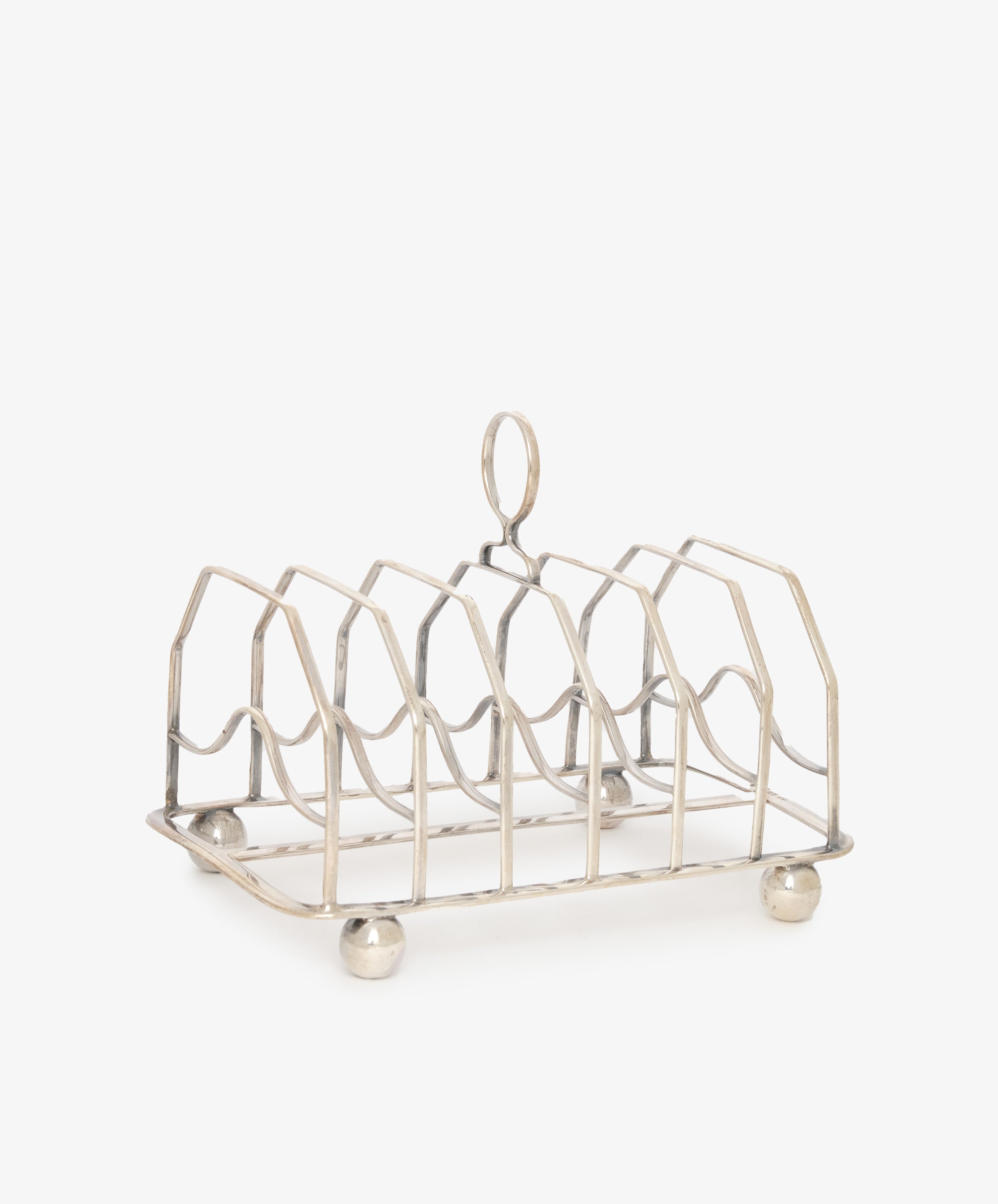The Vintage George III Toast Rack, crafted from English silver with four slots, a central handle, and four round feet, is set against a plain white background—an ideal piece for any vintage collection.
