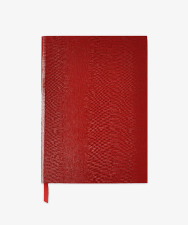 A Red Journal featuring a closed, lizard-embossed cover and matching ribbon bookmark is centered on a white background.
