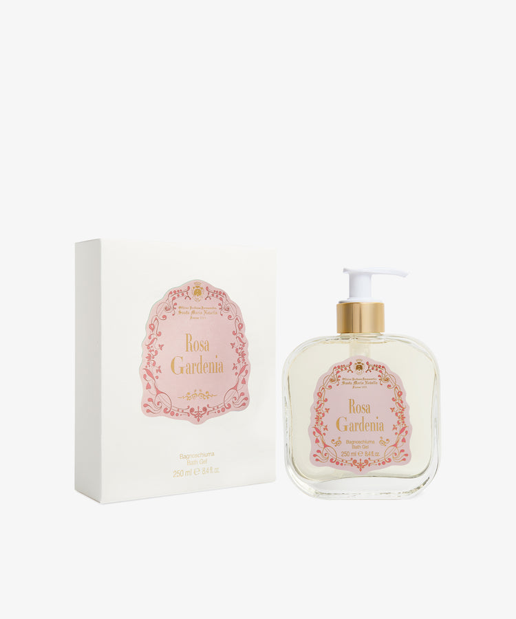 A bottle of Rosa Gardenia Bath Gel with a white pump is displayed beside its coordinating white and pink packaging box.