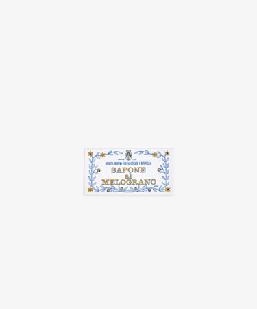 A rectangular label with a blue and gold decorative border reads Melograno Soap in bold, evoking the elegance of Santa Maria Novella’s renowned Italian soap.