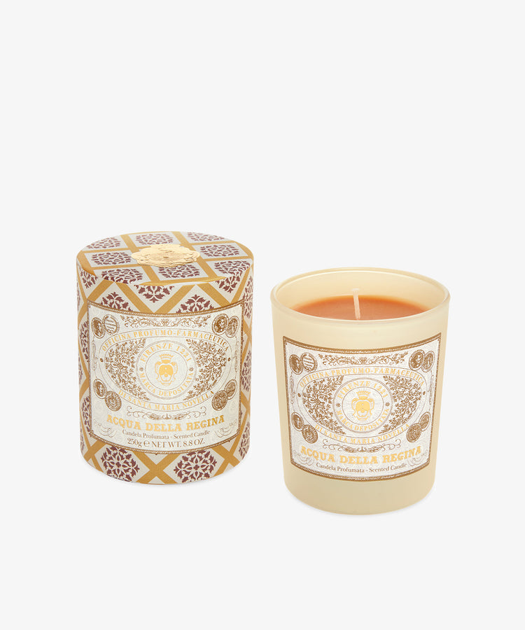The Acqua Della Regina Candle, an iconic Florentine fragrance, comes in a cream glass holder beside its matching patterned box—both labeled with Firenze 1221.