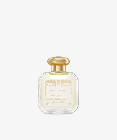 A clear glass bottle of Rosa Gardenia Eau de cologne, featuring a gold cap and white and gold label, is elegantly centered on a plain white background.