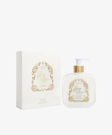 A white and gold pump bottle of Acqua Della Regina Fluid Body Cream appears beside its matching decorative box, reflecting the refined elegance of this classic Florentine scent.