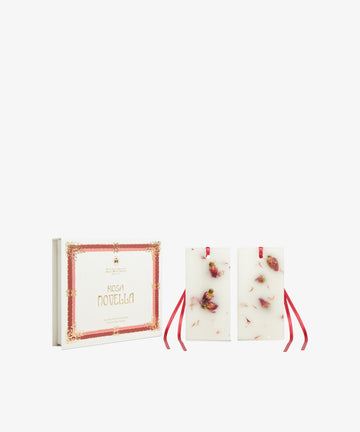 The Rosa Novella Scented Wax Tablets, Set of 2, feature dried flowers and red ribbons, presented in a decorative box that captures the charm of the Tuscan Hills.