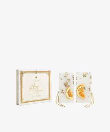 A decorative box sits beside two Aqua della Regina Scented Wax Tablets—rectangular, white, and fragranced with Pot Pourri Cologne—each adorned with dried orange slices, flowers, and a hanging ribbon.