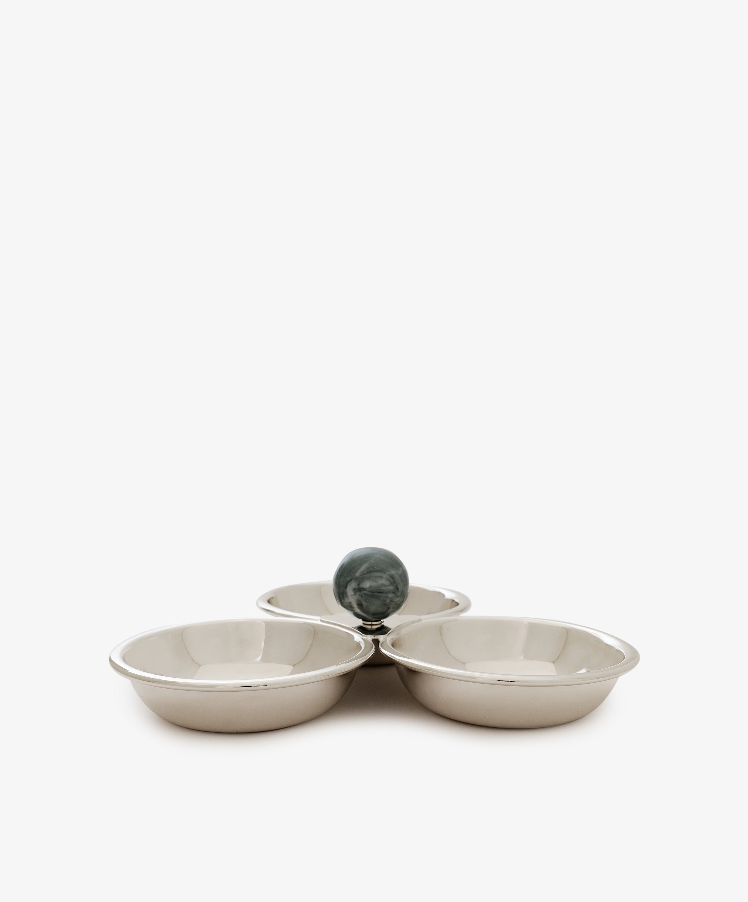 The Paros Triple Bowl Set features three round silver bowls arranged in a clover shape, elegantly accented by a dark green marble sphere at their meeting point.
