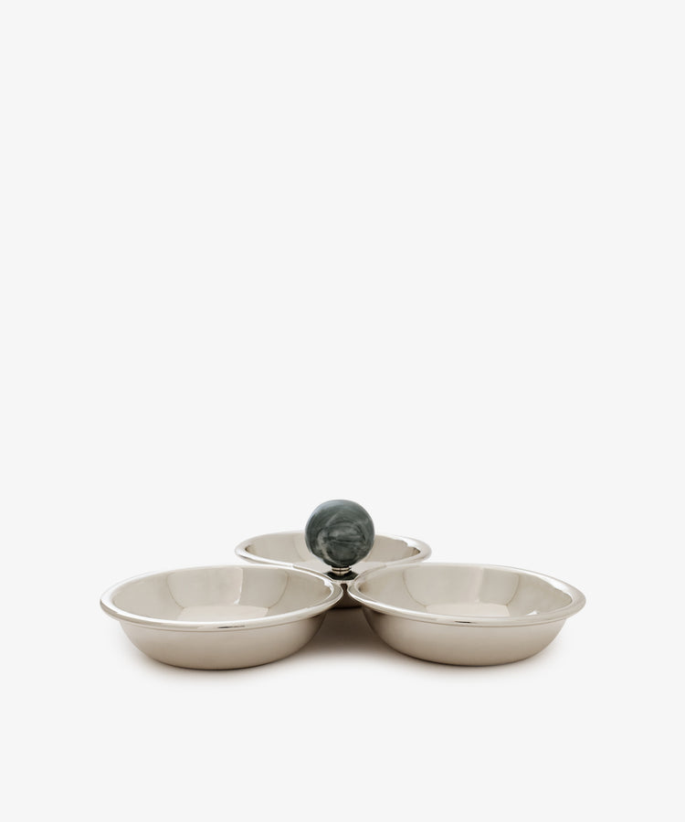 The Paros Triple Bowl Set features three round silver bowls arranged in a clover shape, elegantly accented by a dark green marble sphere at their meeting point.