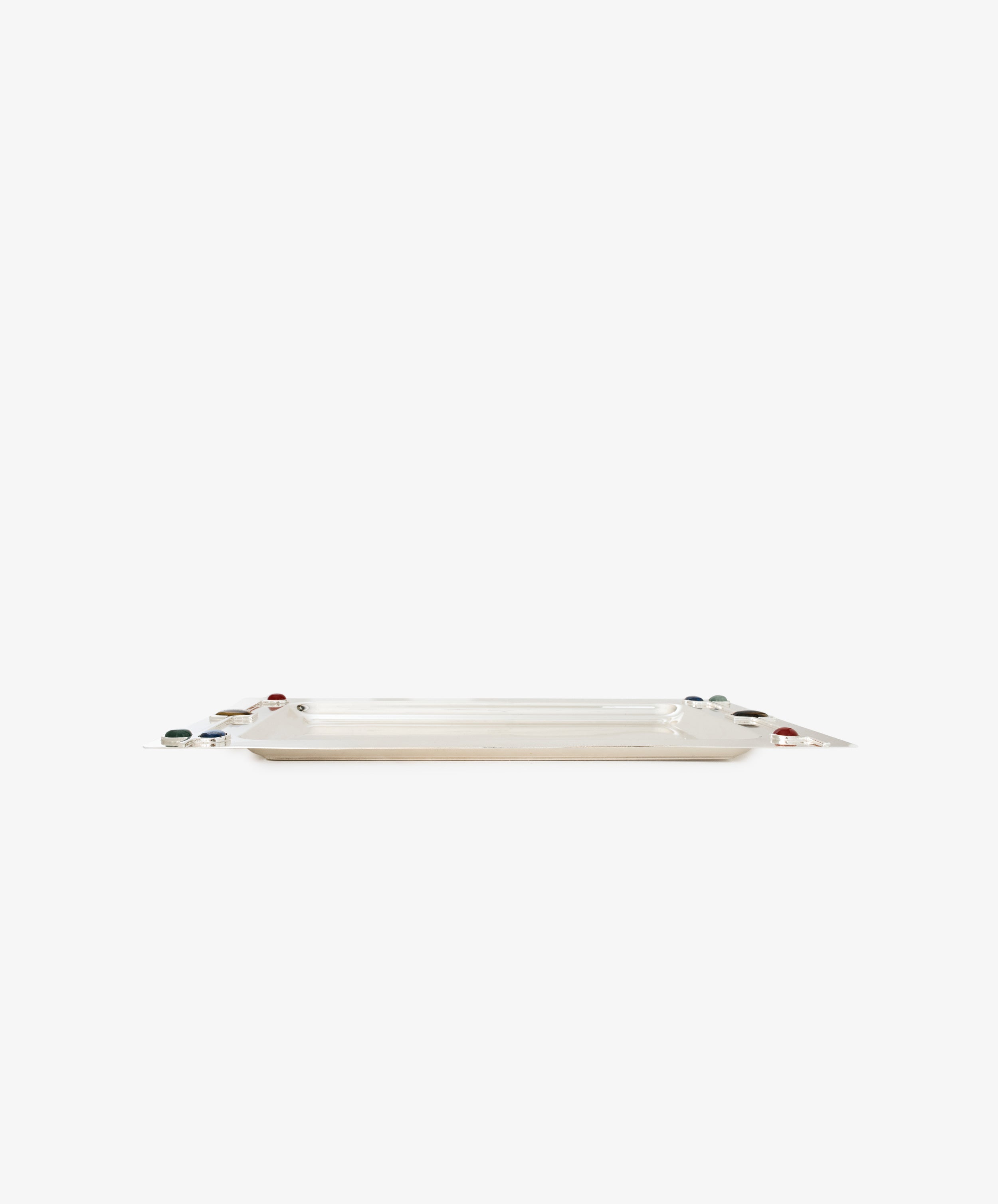 The Verola Rectangle Tray is a polished silver tray with slightly raised edges, featuring small round colorful stone accents at each corner, photographed against a plain white background.