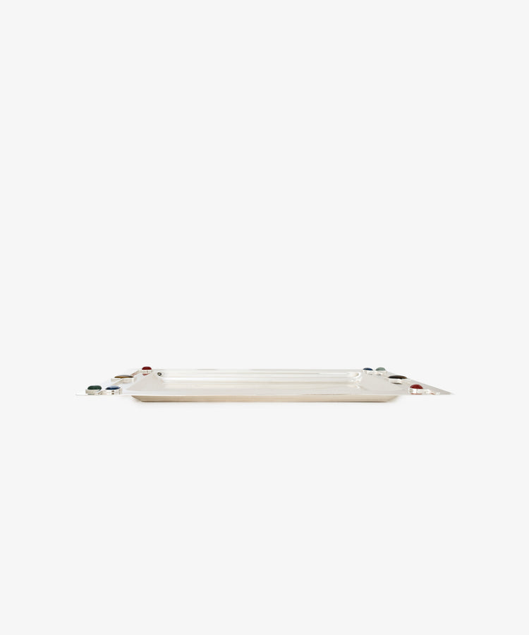 The Verola Rectangle Tray is a polished silver tray with slightly raised edges, featuring small round colorful stone accents at each corner, photographed against a plain white background.
