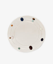 Introducing the Verola Round Tray: a white ceramic serving piece featuring evenly spaced, colorful, round stones embedded around the rim—reminiscent of an eight-stones ring. Placed on a plain white background, this eye-catching tray evokes the elegance of a silver-polished amaro holder and skillfully blends functional design with decorative charm.