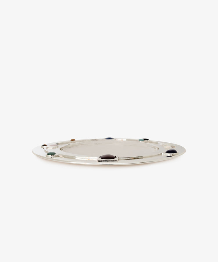 Verola Round Tray: A shiny silver tray with a flat surface, featuring beautifully crafted colored stone rings spaced evenly along the rim, displayed on a plain white background.