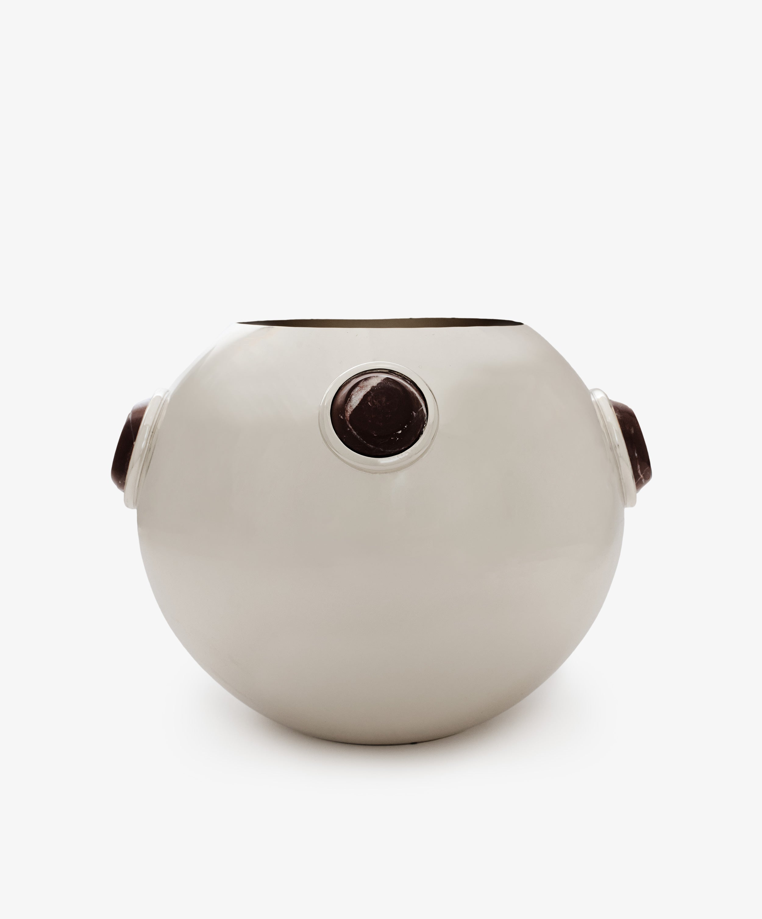 The Paros Round Vase is a white, round ceramic vase featuring three evenly spaced circular dark brown accents around its curved surface, reminiscent of Paros stone. It is displayed against a plain white background.