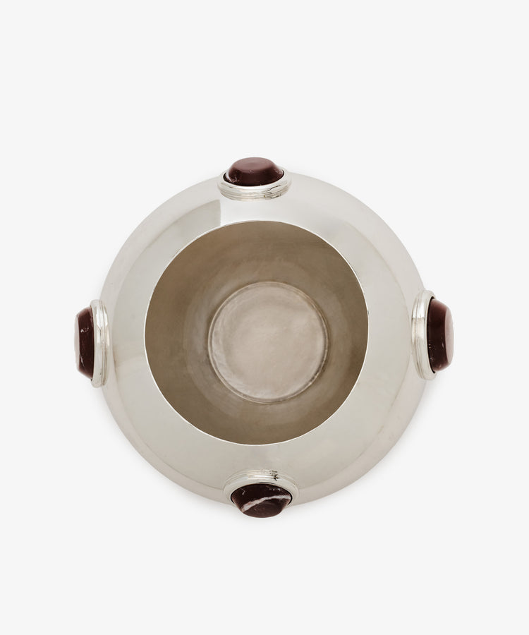 The Paros Round Vase is a silver-toned, round vase with a wide opening, viewed from above and accented by four evenly spaced dark oval stones around its rim—ideal for complementing marble decor or enhancing Paros stone surfaces.