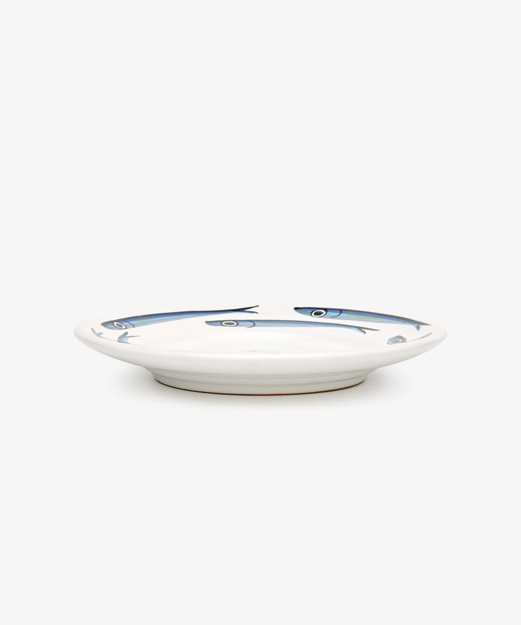 The Tommaso Small Plate, Set of 4, features white ceramic plates with a shallow profile and hand-painted blue fish designs around the rim, evoking an Amalfi Coast vibe.