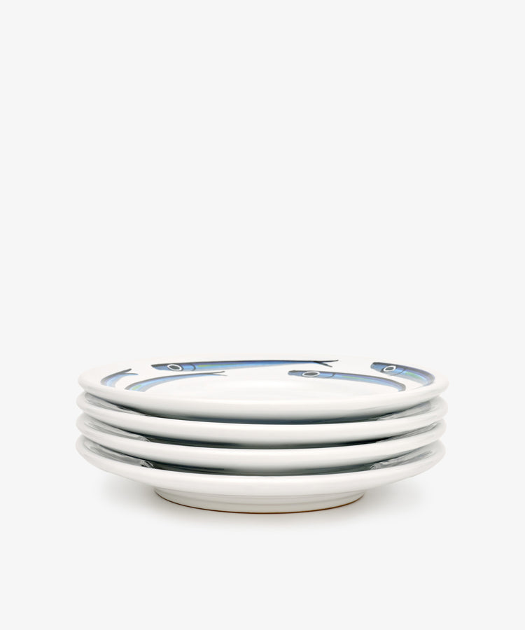 The Tommaso Small Plate, Set of 4, features hand-painted blue fish along the rims on a plain white background—evoking the charm of the Amalfi Coast.