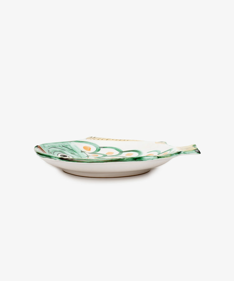 The Rico Serving Platter is a hand-glazed ceramic dish shaped like a fish, with green and orange painted details—a unique handmade tableware piece.