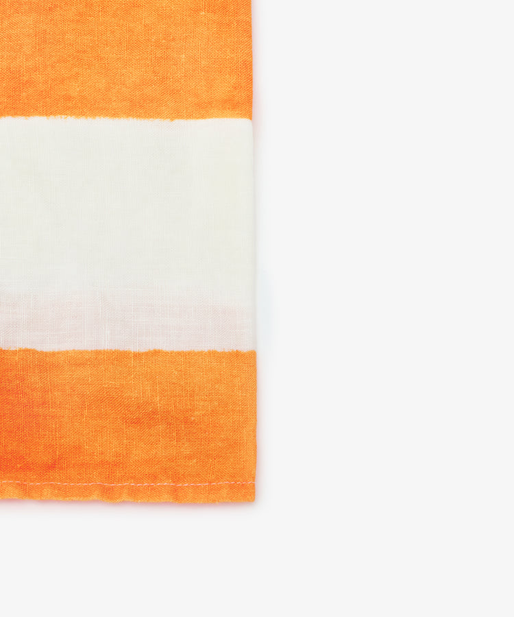 Close-up on white napkin with orange stripe.