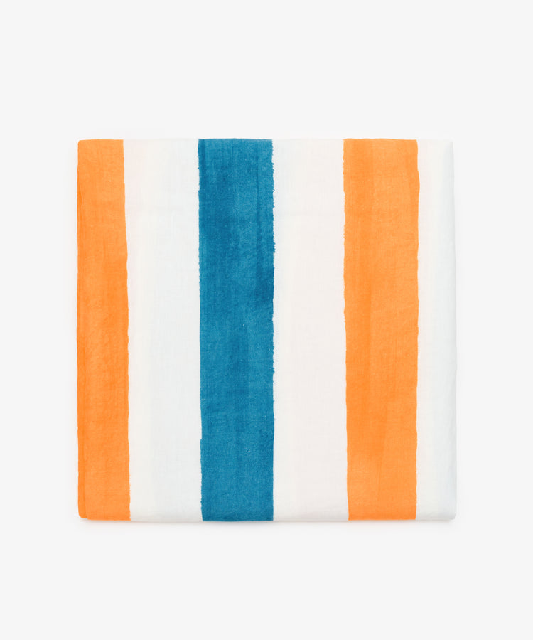 Striped Tablecloth by Summerill & Bishop. Folded white linen cloth in blue and orange stripes.