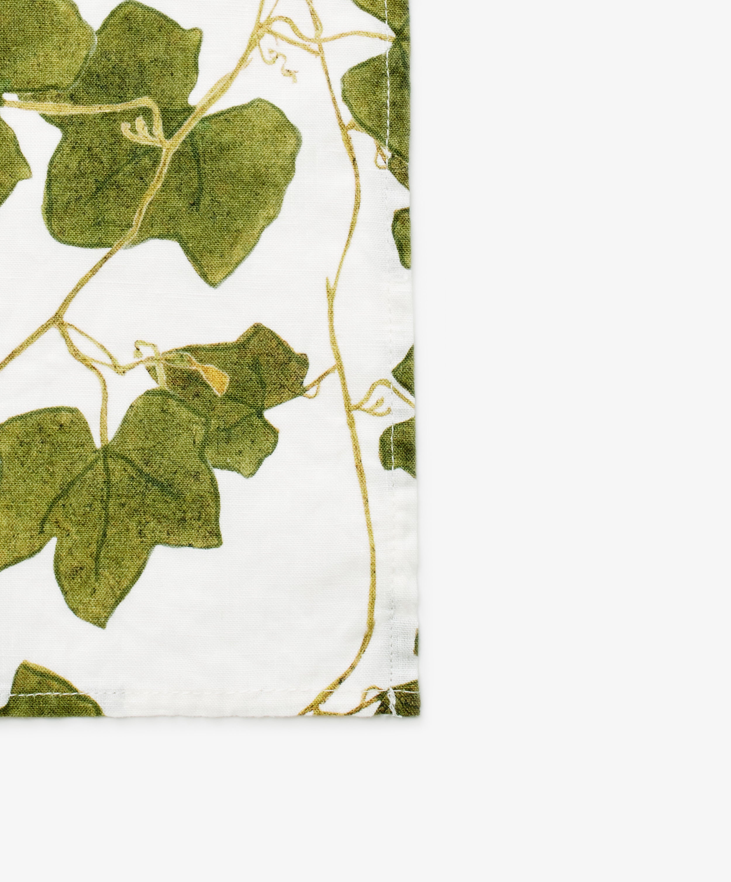 Ivy Herbarium Napkins. Image of set of six napkins. Verdant green vine imagery on napkin. Close up of corner.