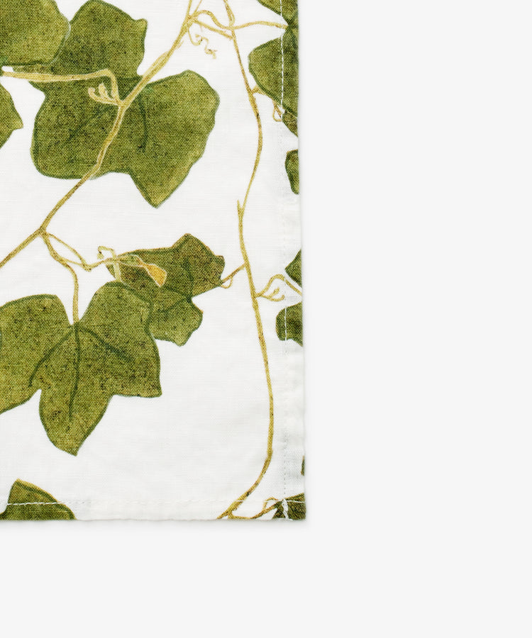 Ivy Herbarium Napkins. Image of set of six napkins. Verdant green vine imagery on napkin. Close up of corner.