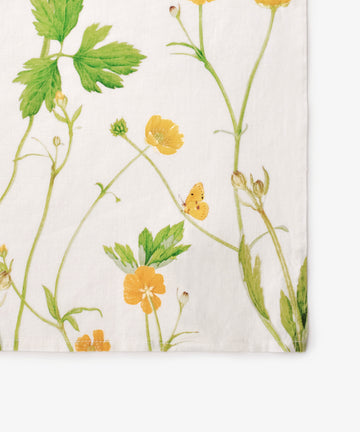 Add charm to your table with the Buttercup Linen Napkin, Set of 6â€”white napkins featuring a botanical print with green leaves, yellow buttercup flowers, and a small yellow butterfly.