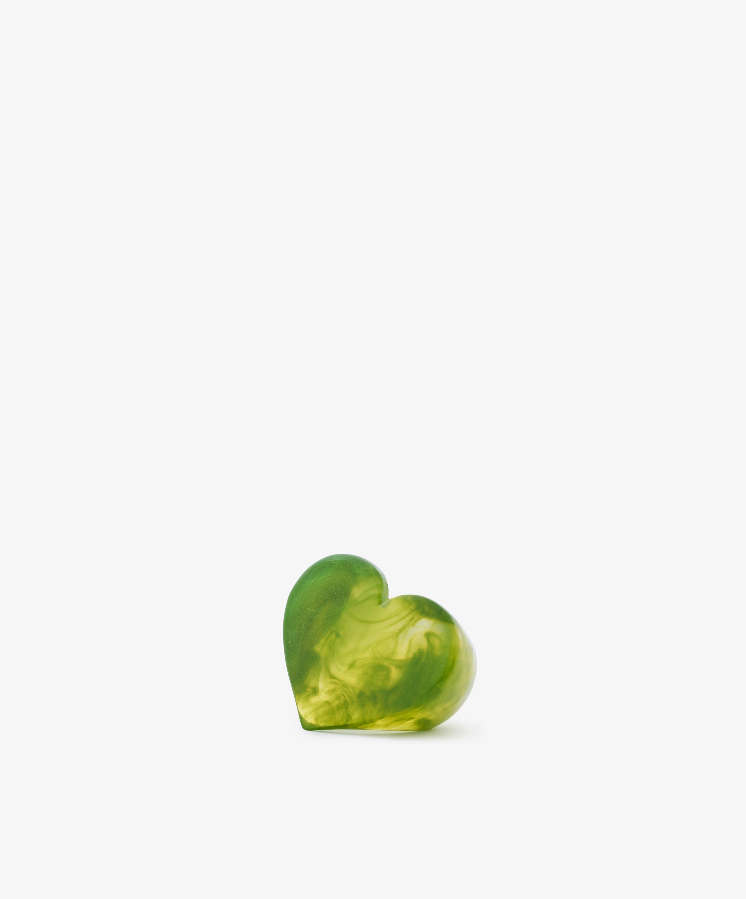 A Heart Resin Napkin Ring, featuring a small, green, heart-shaped design with a marbled pattern and sculptural form, is centered near the bottom of a plain white background.
