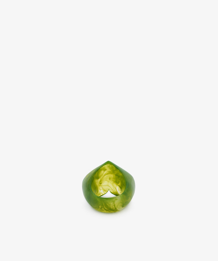 A green, marbled resin ring with a smooth, rounded shape and sculptural form, displayed upright on a plain white background.