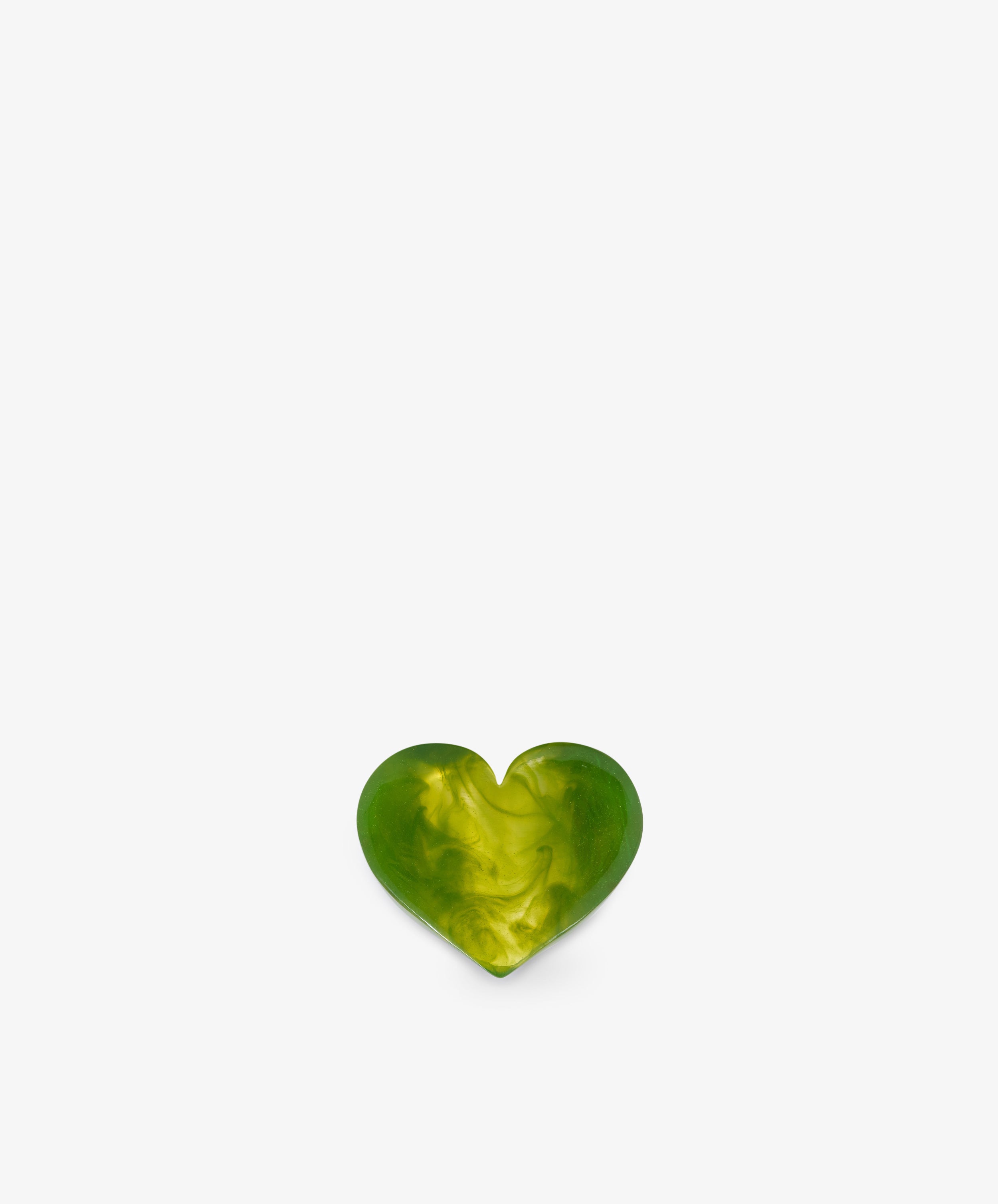 A small, green and yellow marbled heart-shaped object, reminiscent of a sculptural form, is centered at the bottom of a plain white background.