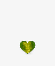 A small, green and yellow marbled heart-shaped object, reminiscent of a sculptural form, is centered at the bottom of a plain white background.