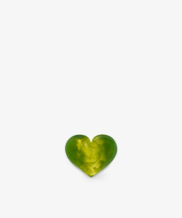 A small, green and yellow marbled heart-shaped object, reminiscent of a sculptural form, is centered at the bottom of a plain white background.