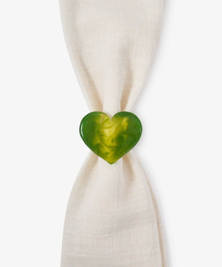 A sculptural Heart Resin Napkin Ring in green, symbolizing love, holds a white cloth napkin against a plain white background.