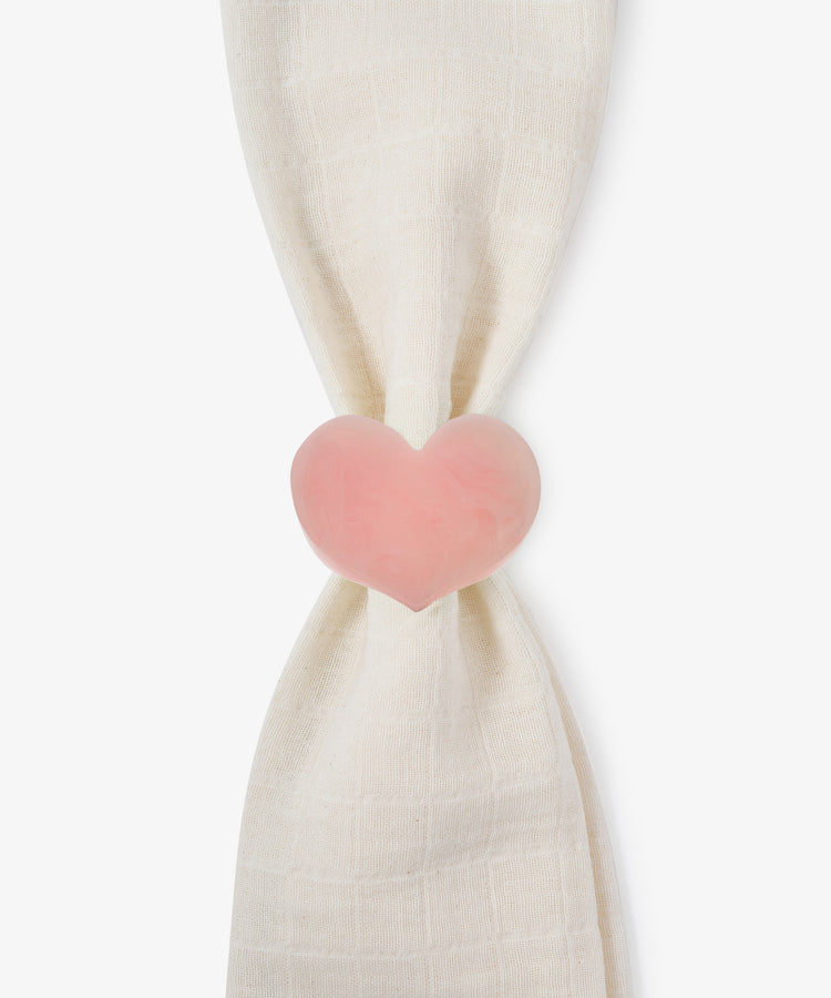 A white cloth is gathered and held together by the Heart Resin Napkin Ring—a pink, heart-shaped clip crafted from smooth resin—creating a sculptural form that doubles as a charming love decor accent.