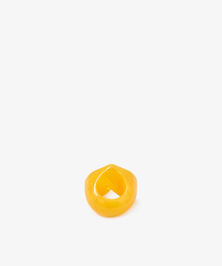 The Heart Resin Napkin Ring—a chunky, glossy, yellow ring with a pointed top reminiscent of a sculptural form—is displayed upright on a plain white background.