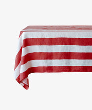 A rectangular table draped with the Striped Tablecloth, featuring festive red stripes, set against a plain white background.