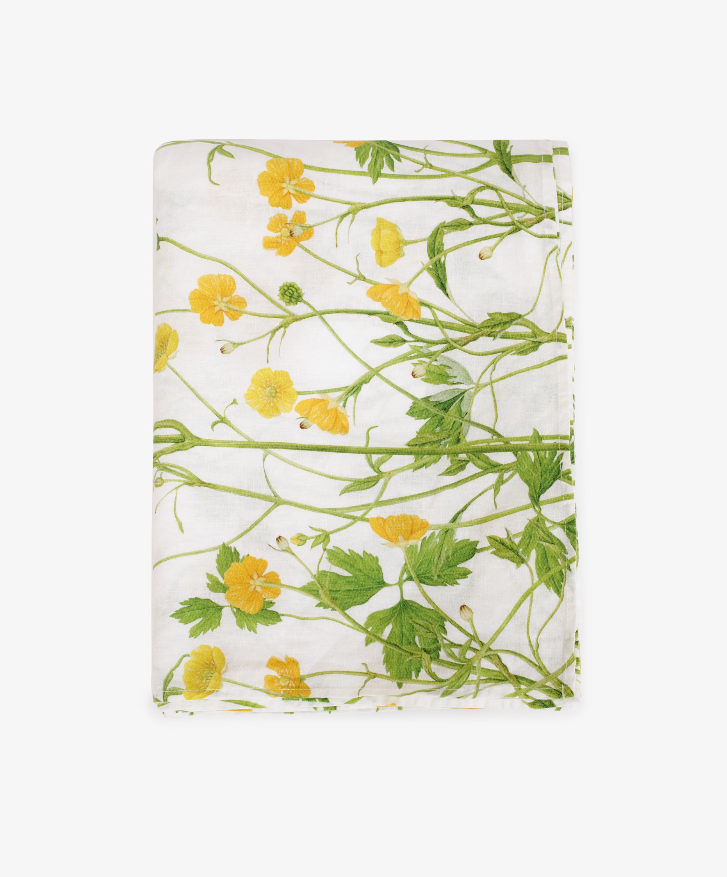 The Buttercup Linen Tablecloth features a white base with green stems and yellow buttercup flowers, neatly folded against a plain white background—ideal for chic garden table decor.