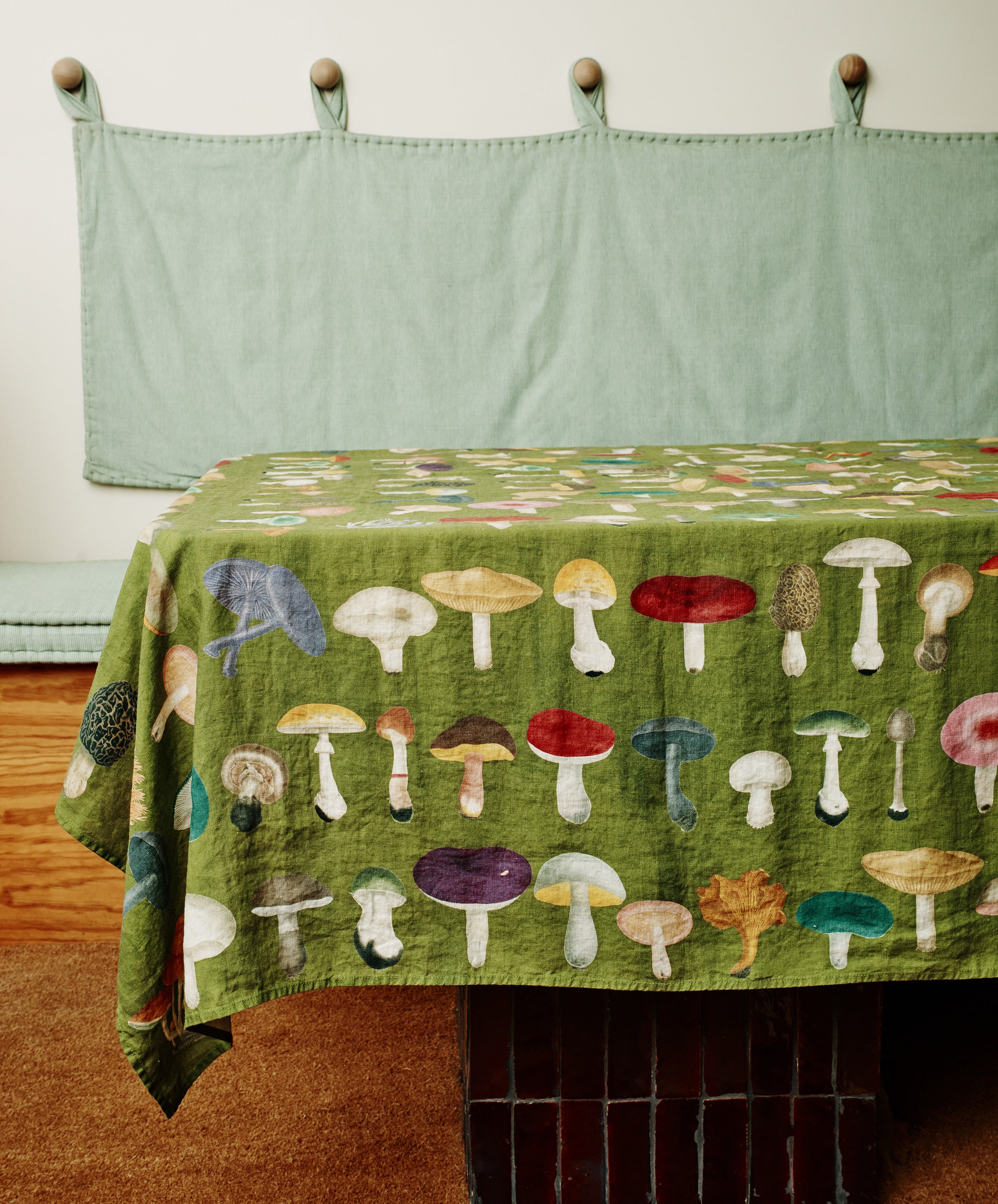 John Derian Fungi Tablecloth. Image of tablecloth draped over a table. Side view.