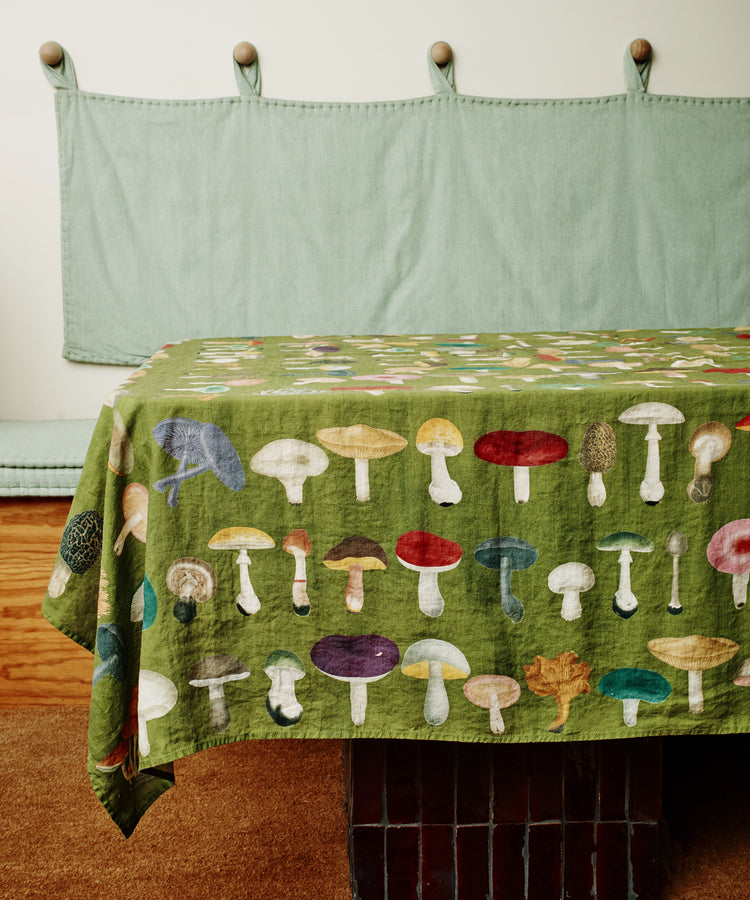 John Derian Fungi Tablecloth. Image of tablecloth draped over a table. Side view.